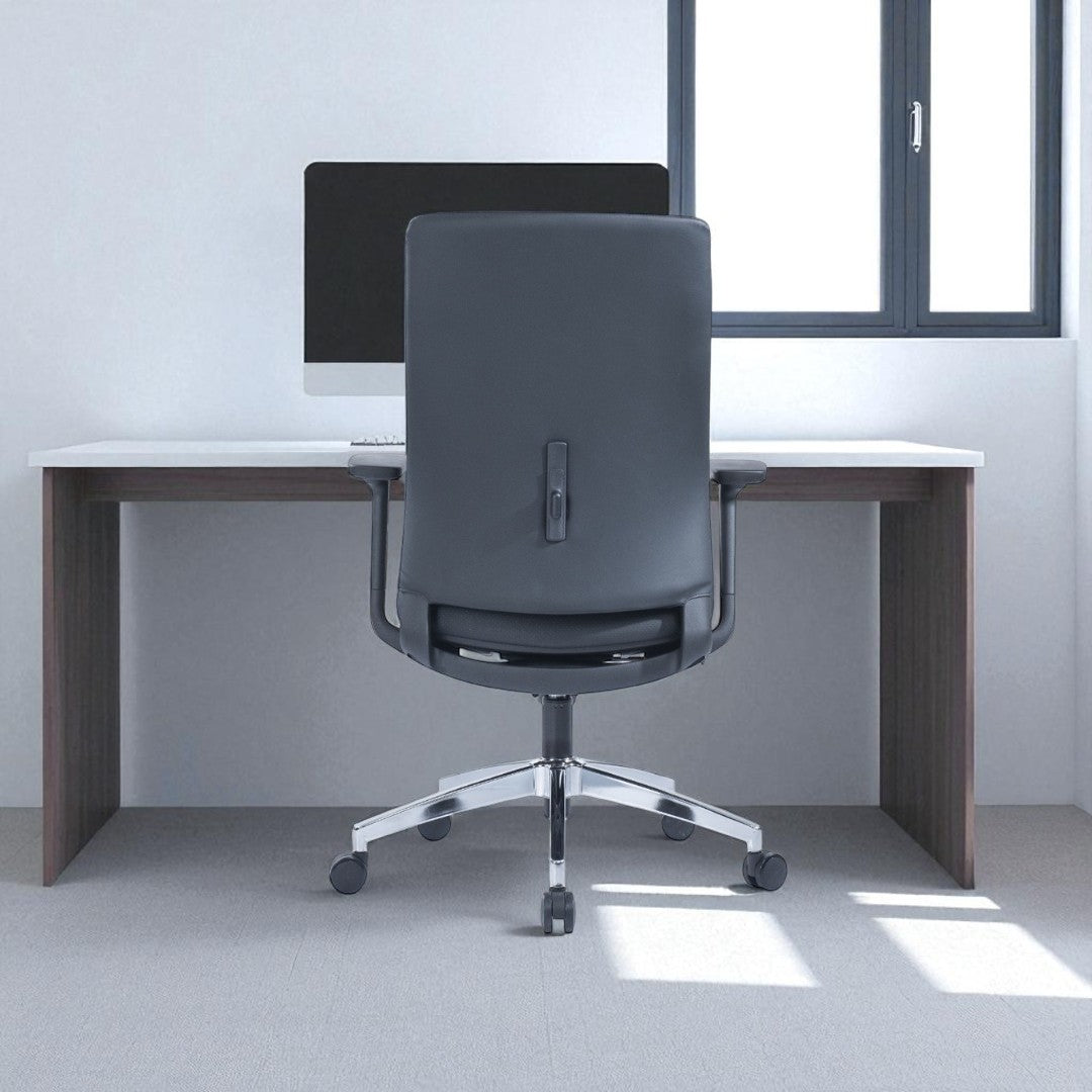 Gray office chair in front of a wooden desk with a computer monitor.