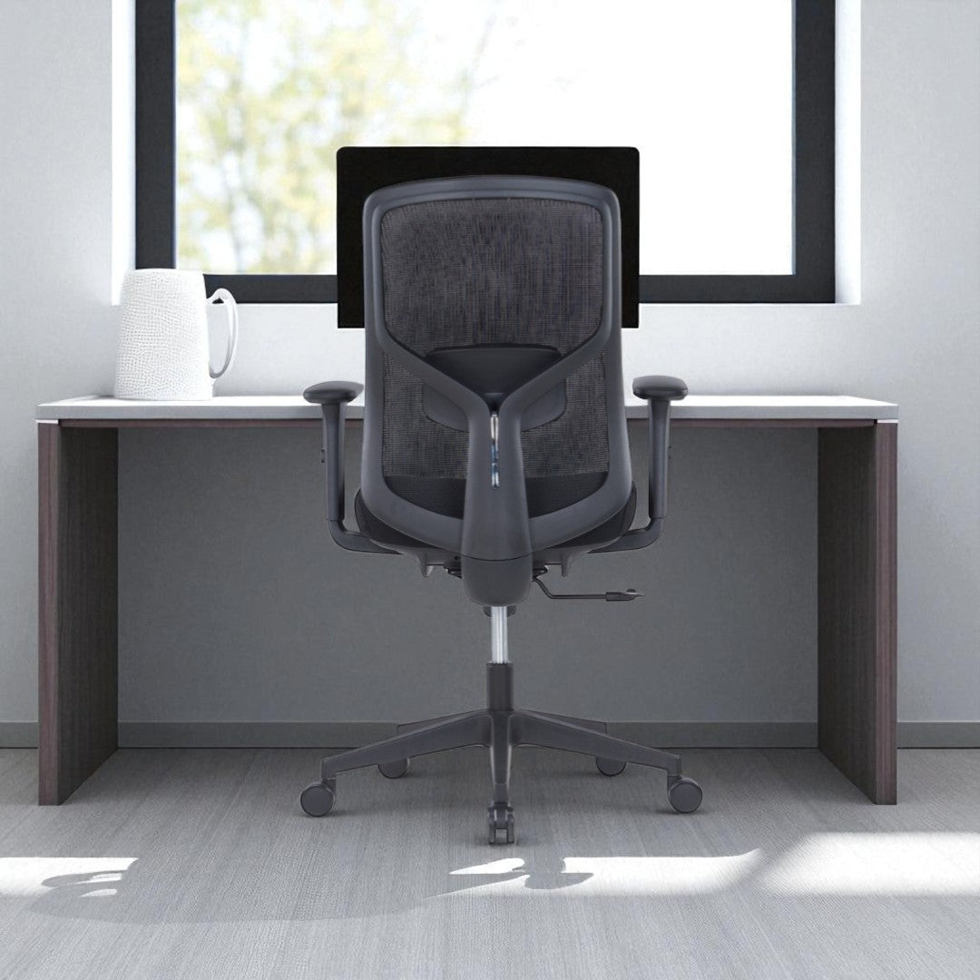 Gray office chair in front of a desk with a window in the background
