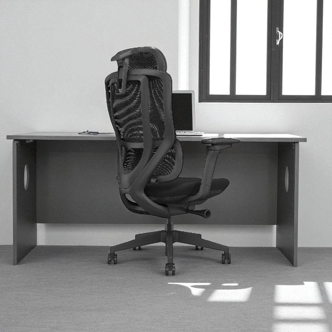 Black office chair in front of a desk with a laptop in a minimalistic office setting.