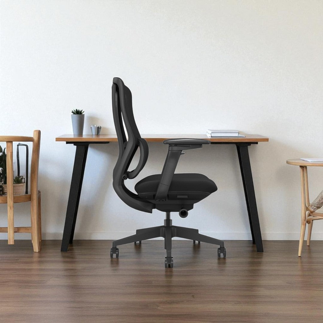 Black office chair in front of a wooden desk with a minimalistic background