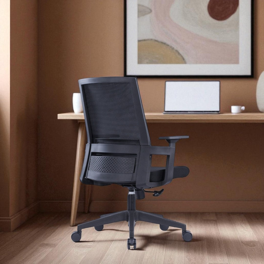 Black office chair in a home office setting with a desk and abstract art on the wall.